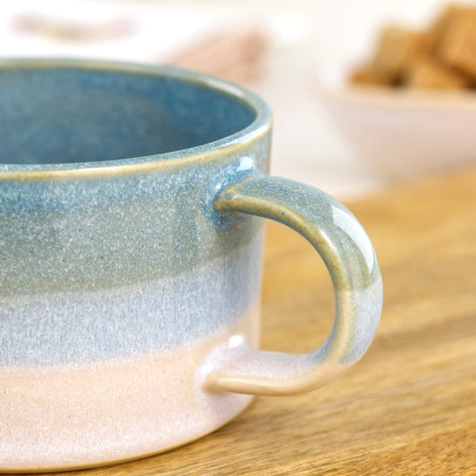 Close up of Sea Smoothed Pebble glaze on handmade blue and white cappuccino mug with glossy speckled coastal tones