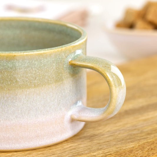Detail of glossy Pale Green glaze blending into white on handcrafted cappuccino cup, speckled studio pottery finish