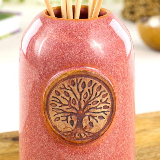 Close up of coral scent diffuser with Tree of Life ceramic applique and glossy speckled glaze