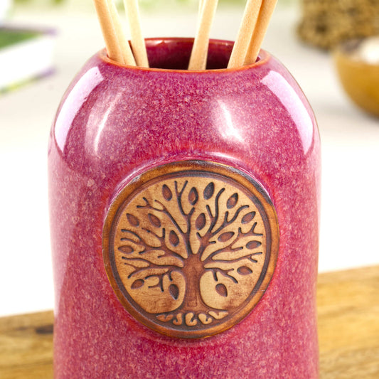 Close up of crimson fragrance diffuser with Tree of Life applique and glossy mottled red glaze