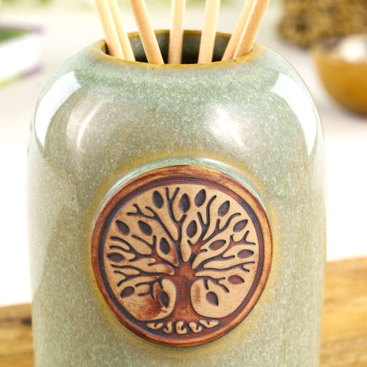 Close up of pale green scent diffuser with Tree of Life ceramic applique and glossy soft green glaze