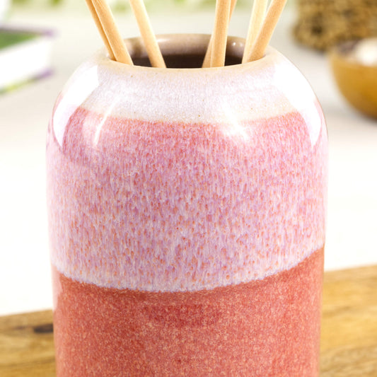 Close-up of layered flowing coral and white glazes on a ceramic reed diffuser with glossy speckled finish - Sea Smoothed Pebble glaze