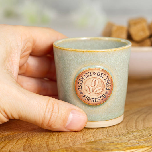 Wheel-thrown stoneware espresso cup in hand showing small espresso size and tactile feel
