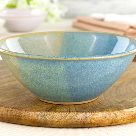Close-up of a wheel-thrown stoneware bowl with layered Coastal Blue and Pale Green glazes, showing the softly speckled finish and handcrafted ceramic texture