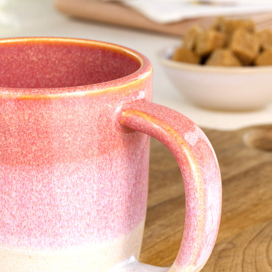 Close-up of the handle and layered Coral and White glaze on a handmade ceramic mug from my small UK pottery studio