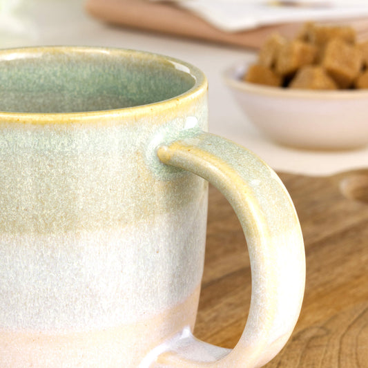 Close-up of the handle and layered Pale Green and White glaze on a handmade pottery mug from a British studio