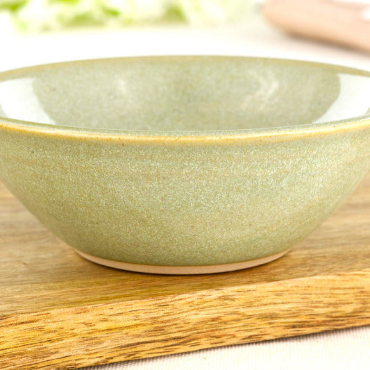 Close-up of Pale Green Sea Smoothed Pebble glaze on a wheel-thrown stoneware bowl with soft natural speckling