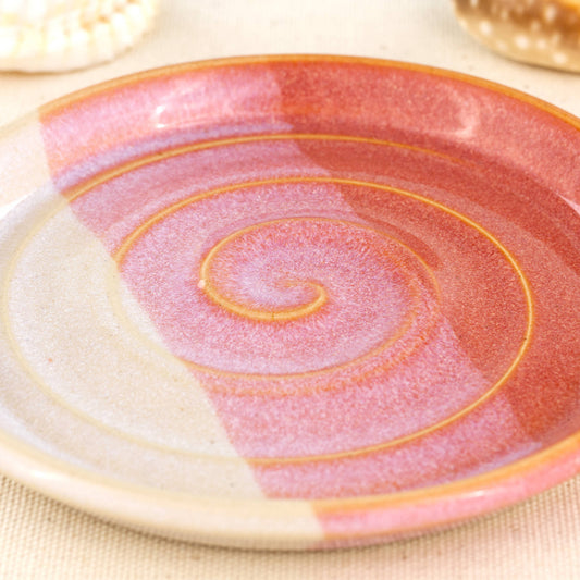Close up of coral and white soap dish, overlapping glazes with spiral ridges and glossy double dipped finish
