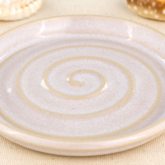 Close up of white glazed ceramic soap dish with spiral pattern, speckled handmade stoneware soap saver tray