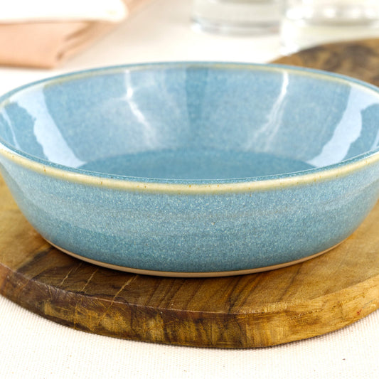 Close-up of a handmade stoneware tapas bowl in Coastal Blue, highlighting the glossy speckled glaze, artisan finish and flatter shape designed for tapas-style serving