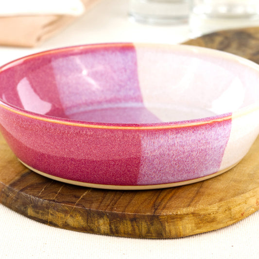 Close-up of a handmade stoneware tapas bowl in Crimson & White, highlighting the glossy speckled glaze, layered red and white tones and shallow serving bowl shape