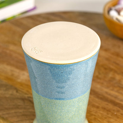 Handmade coastal blue and pale green ceramic bud vase with a tapered silhouette, wheel-thrown stoneware and a smooth unglazed base stamped with the maker’s mark.