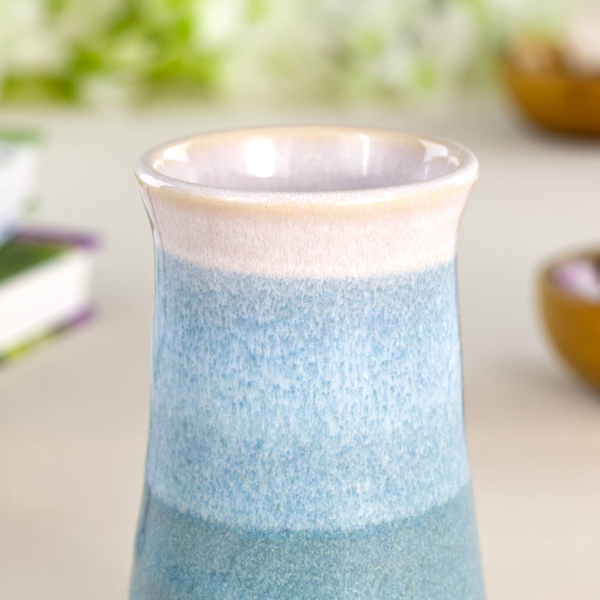 Close-up of a handmade Coastal Blue and white ceramic bud vase, featuring overlapping glazes and a softly speckled stoneware finish.