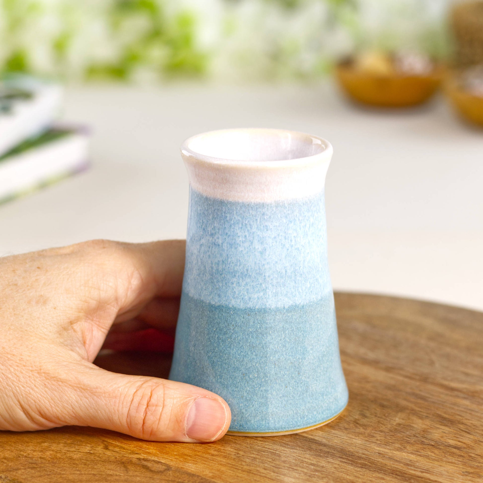 Small handmade Coastal Blue and white bud vase held in hand, wheel-thrown stoneware ideal for single stems or minimalist home décor.