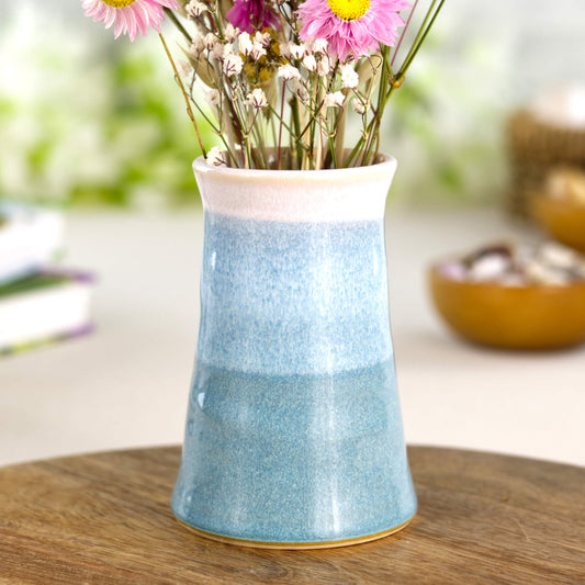 Handmade Coastal Blue and white ceramic bud vase styled on a wooden surface, a double-glazed stoneware piece inspired by coastal tones.