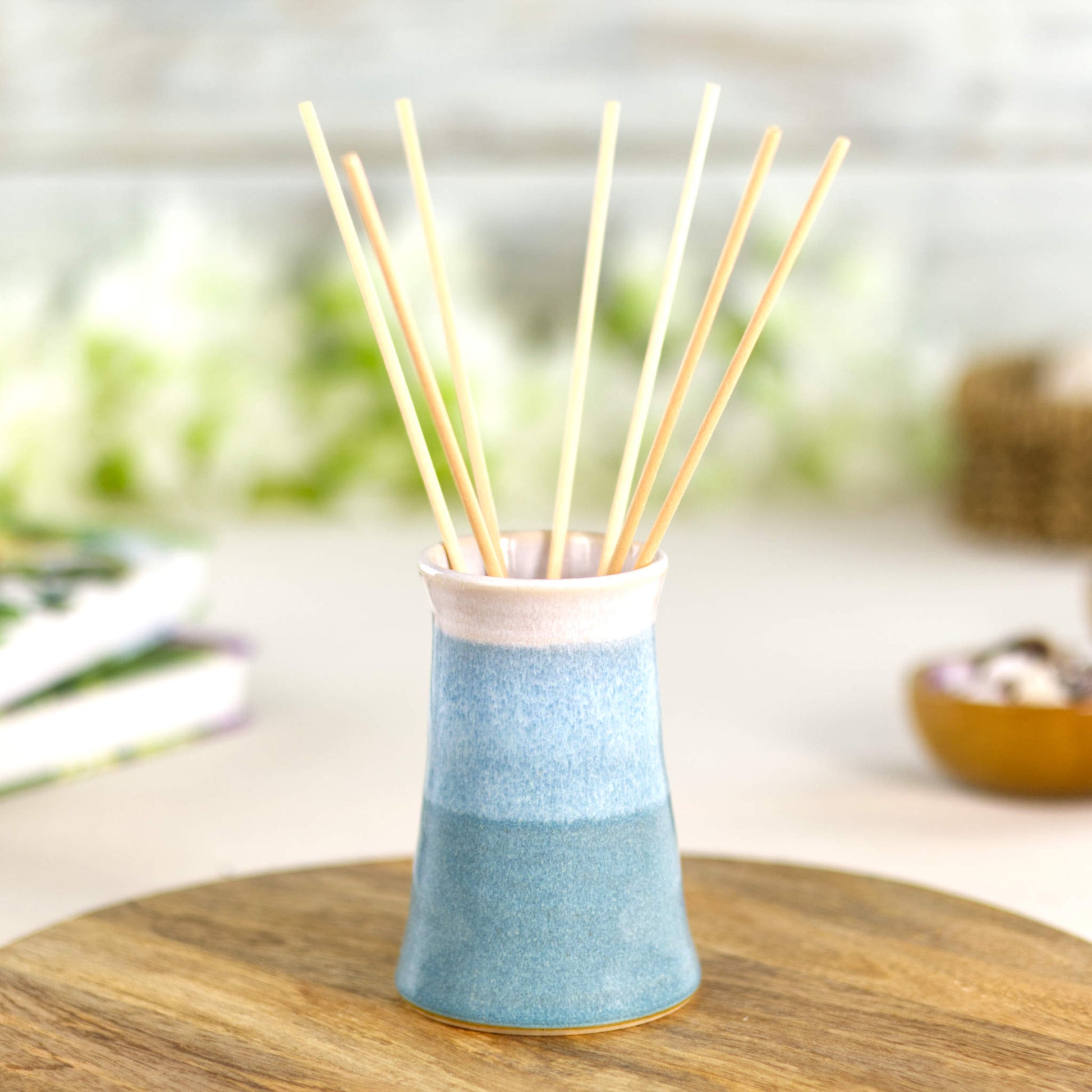 Handmade Coastal Blue and white ceramic bud vase used as a reed diffuser, a hand-thrown stoneware piece for minimalist interior décor.