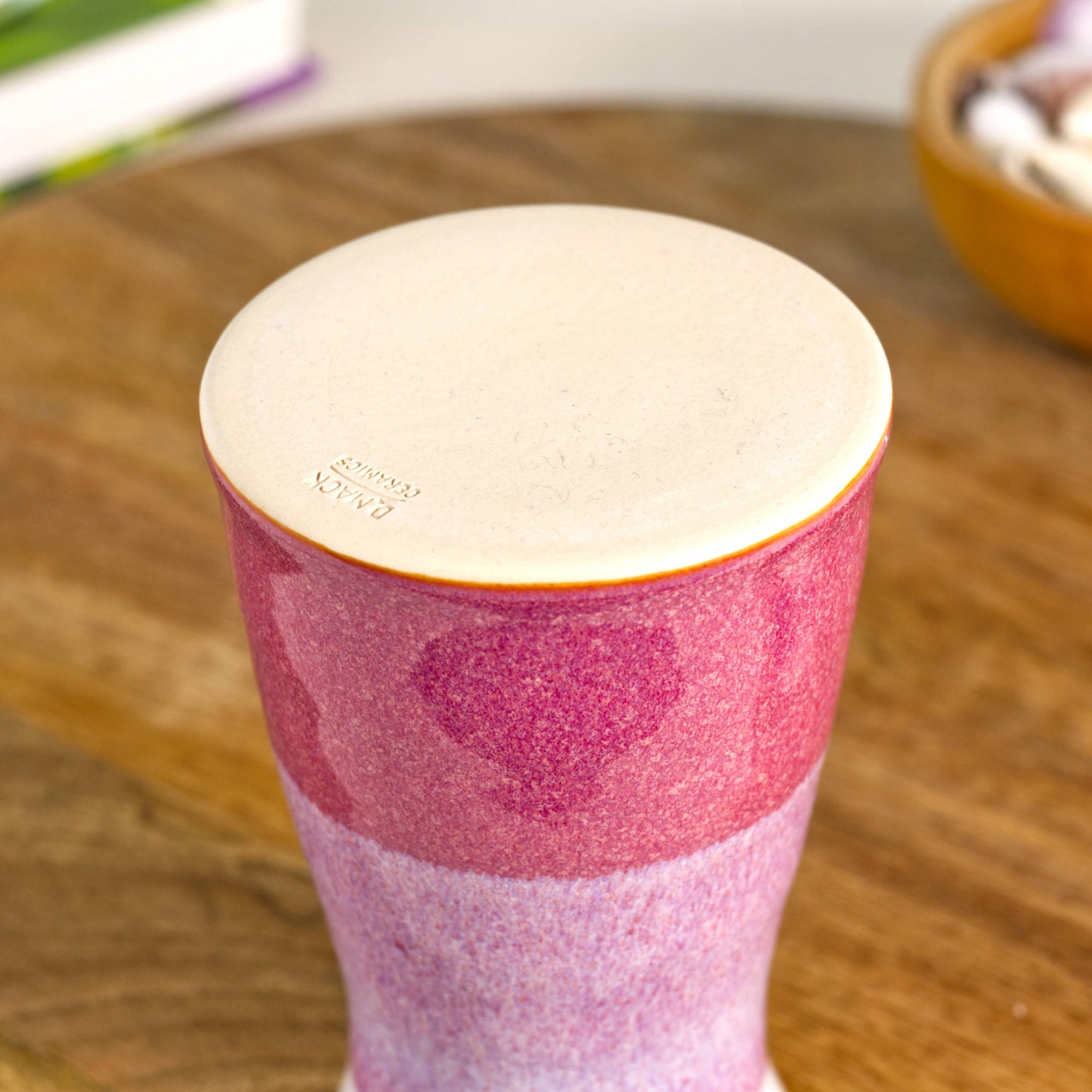 Handmade tapered ceramic bud vase in crimson and white, featuring a two-tone glazed finish, smooth burnished base, and artisan maker’s mark on the underside.