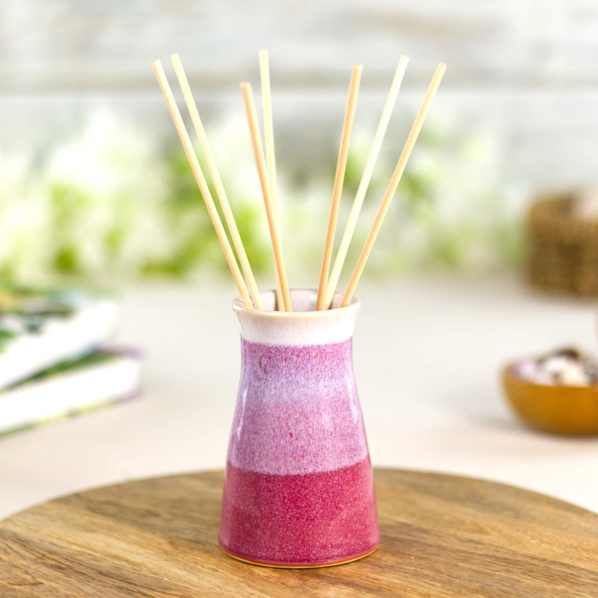 Artisan crimson and white ceramic reed diffuser vase with a white-rimmed neck, textured glaze flow, and a stylish tapered profile ideal for modern home fragrance displays.