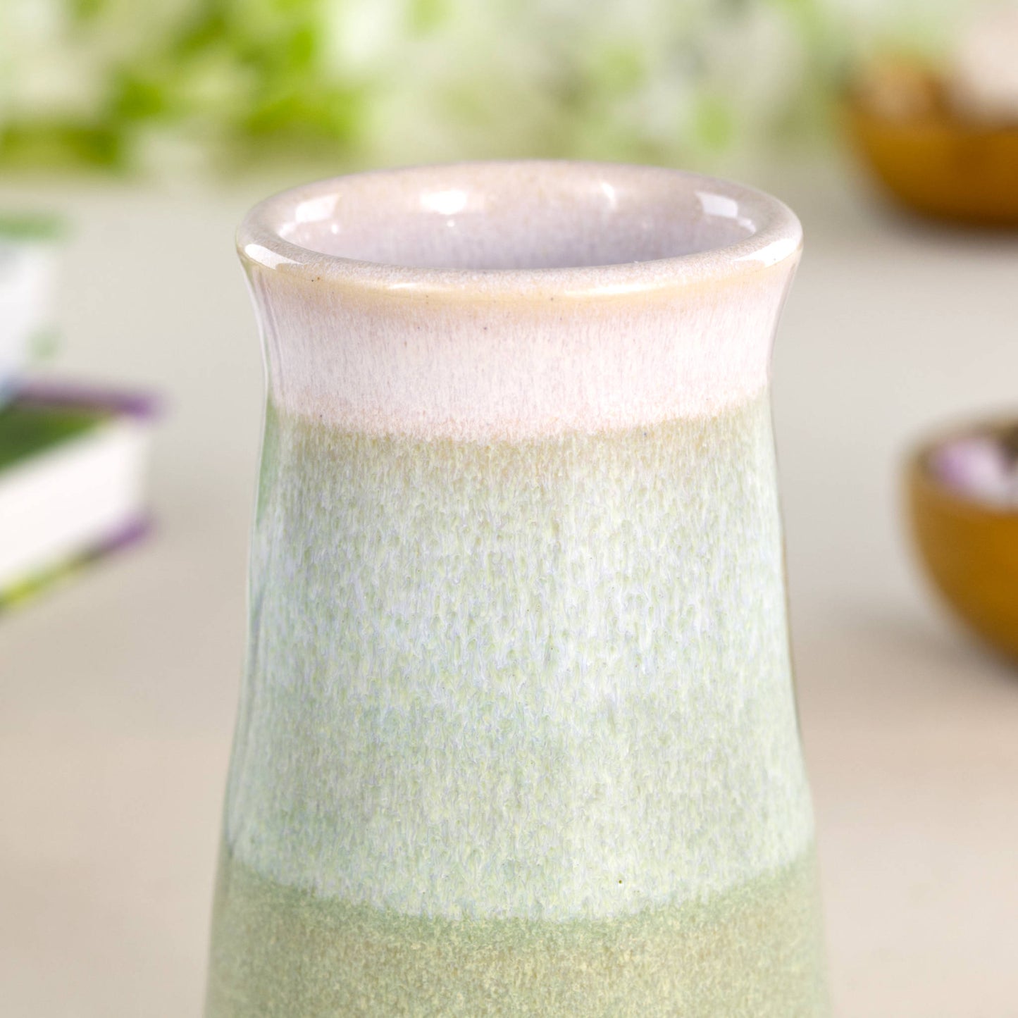 Close-up of a Pale Green and white double-dipped ceramic bud vase, showcasing layered glazes on a handmade conical stoneware form.