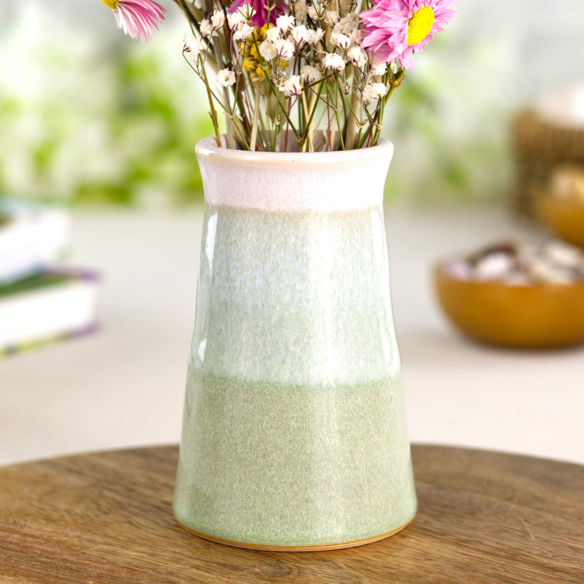 Faded Green and white handmade cone bud vase on a wooden surface, a nature-inspired stoneware piece for modern home décor.