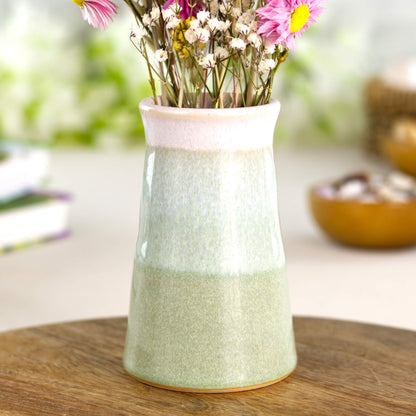 Faded Green and white handmade cone bud vase on a wooden surface, a nature-inspired stoneware piece for modern home décor.