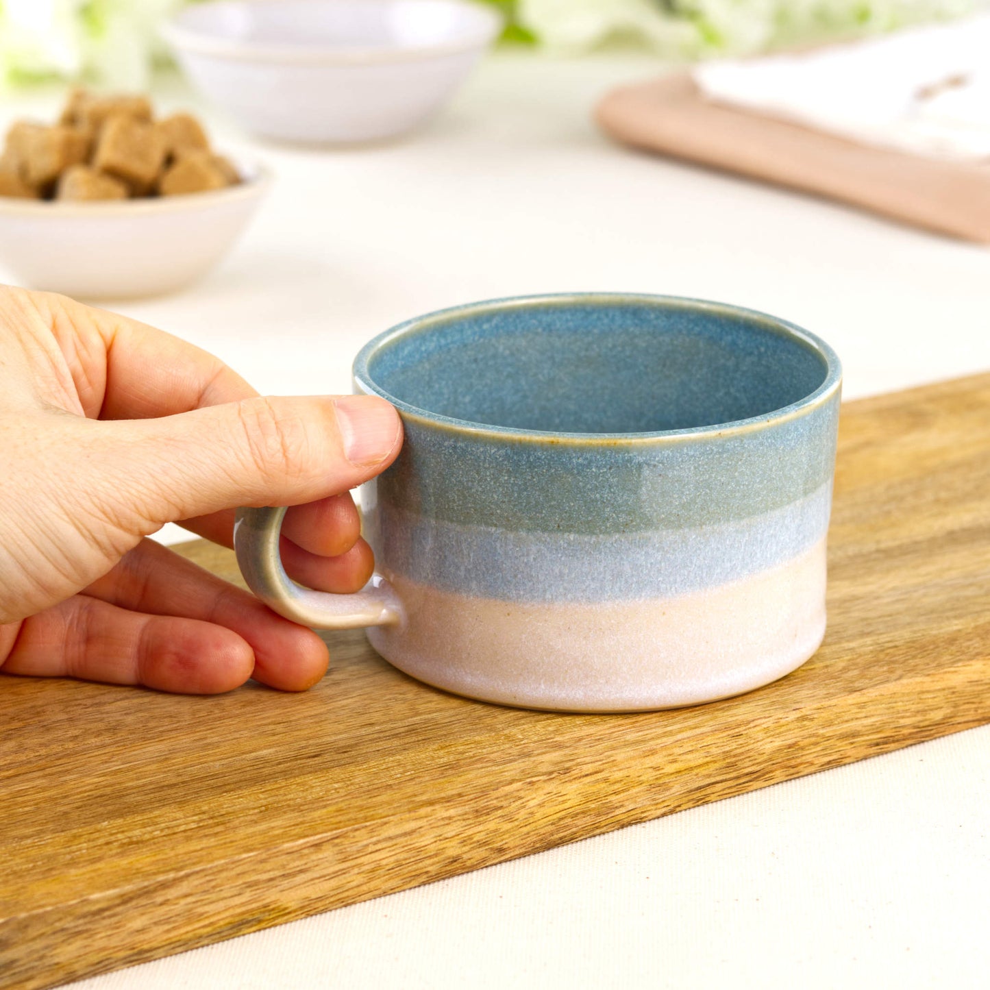 Coastal Blue and White ceramic cappuccino cup held in hand showing café-style shape and generous flat white size