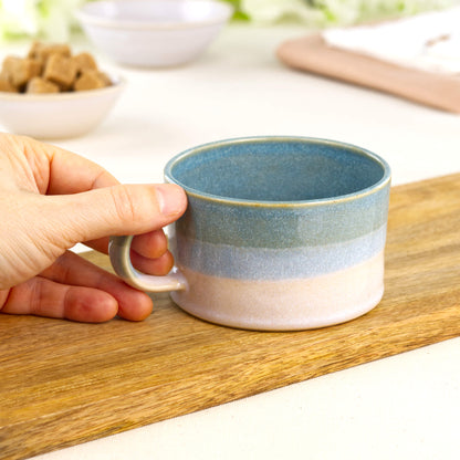 Coastal Blue and White ceramic cappuccino cup held in hand showing café-style shape and generous flat white size