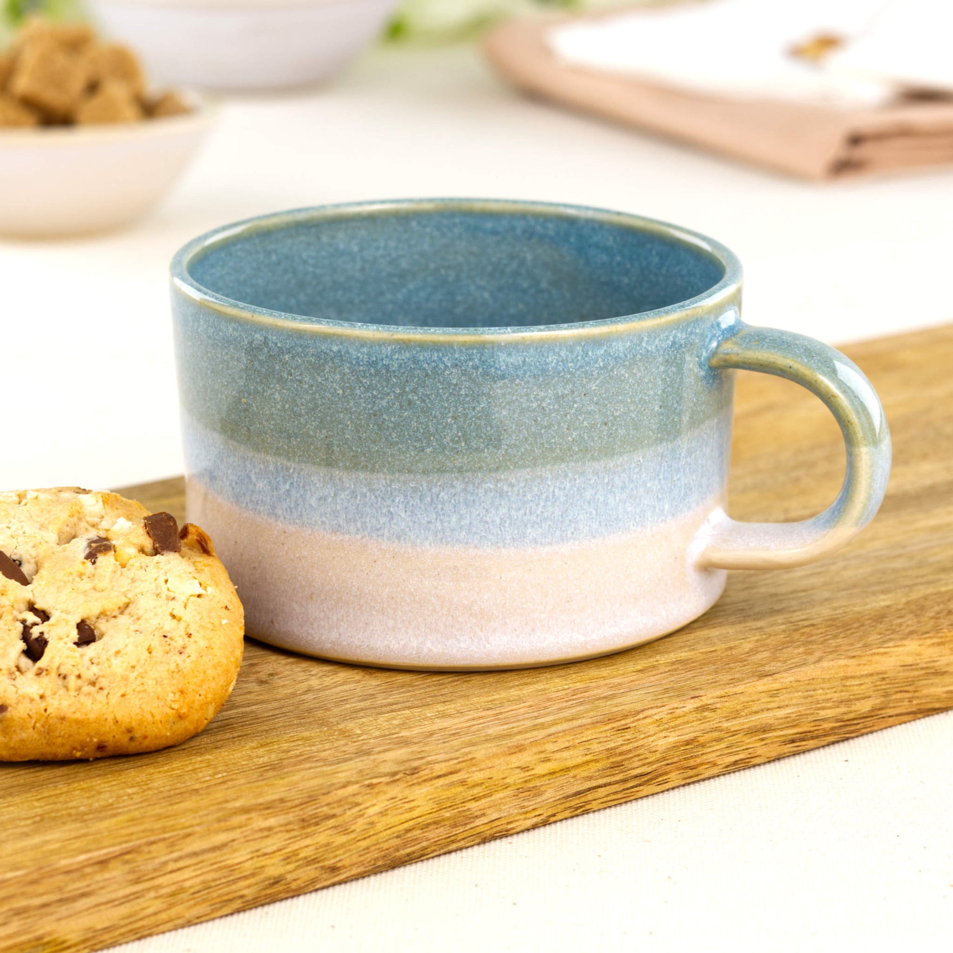 Handmade Coastal Blue and White cappuccino cup in layered glaze finish on oak board with cookie, wheel-thrown stoneware flat white cup