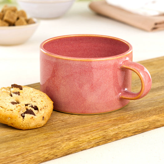 Handmade coral cappuccino cup on oak board with homemade cookie, warm stoneware coffee cup for flat whites and lazy weekend mornings