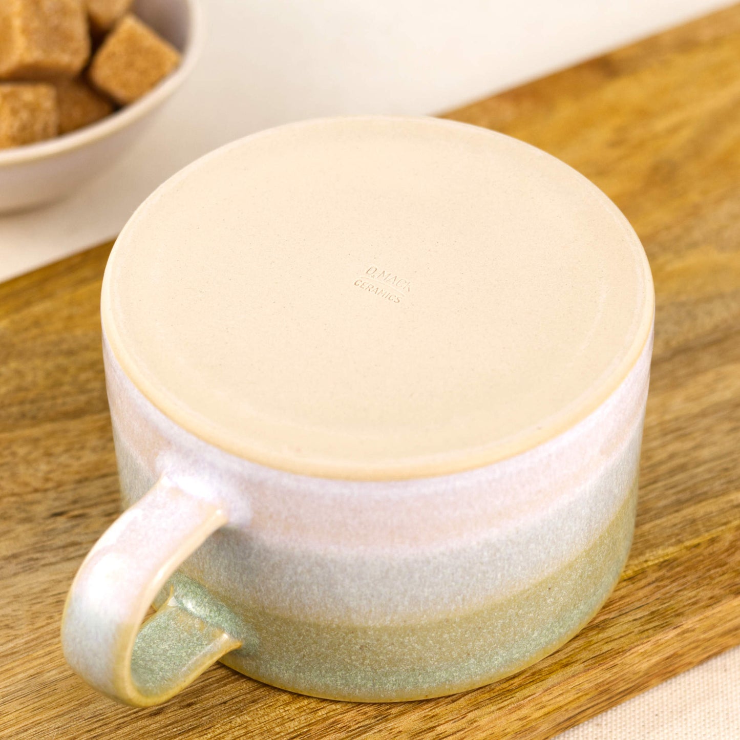 Underside of handmade ceramic cappuccino cup showing smooth unglazed burnished base and impressed maker’s mark