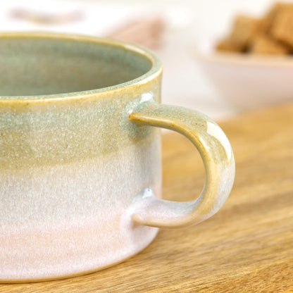 Detail of glossy Pale Green glaze blending into white on handcrafted cappuccino cup, speckled studio pottery finish