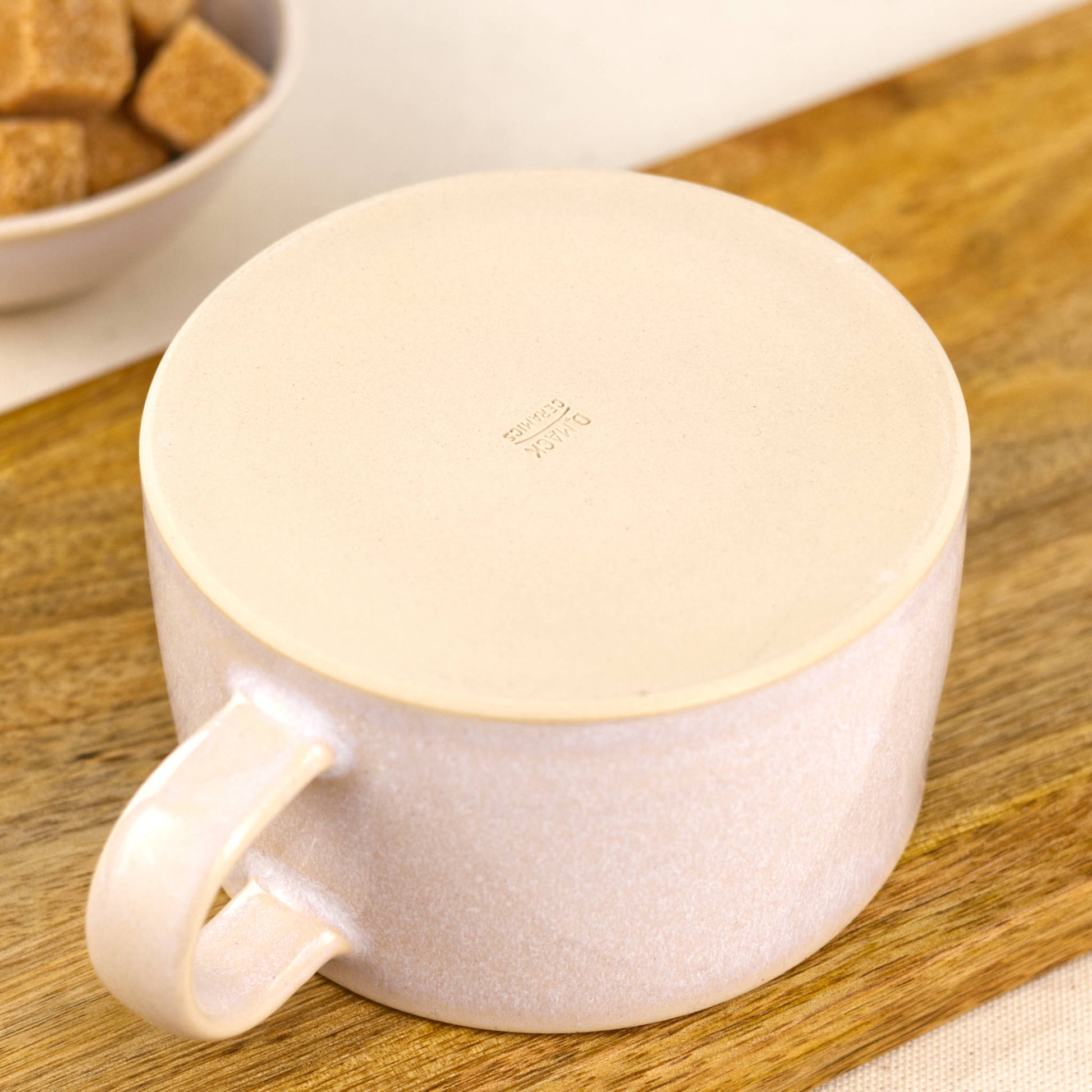 Flat base of handcrafted white cappuccino cup with maker’s mark, smooth stoneware underside from Sussex pottery studio