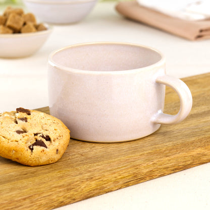 Handmade white cappuccino cup on oak board with biscuit, barista style stoneware cup for flat whites and fresh roasted coffee