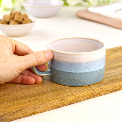 White and Coastal Blue ceramic coffee cup held in hand, wheel-thrown cappuccino cup with wide café style shape