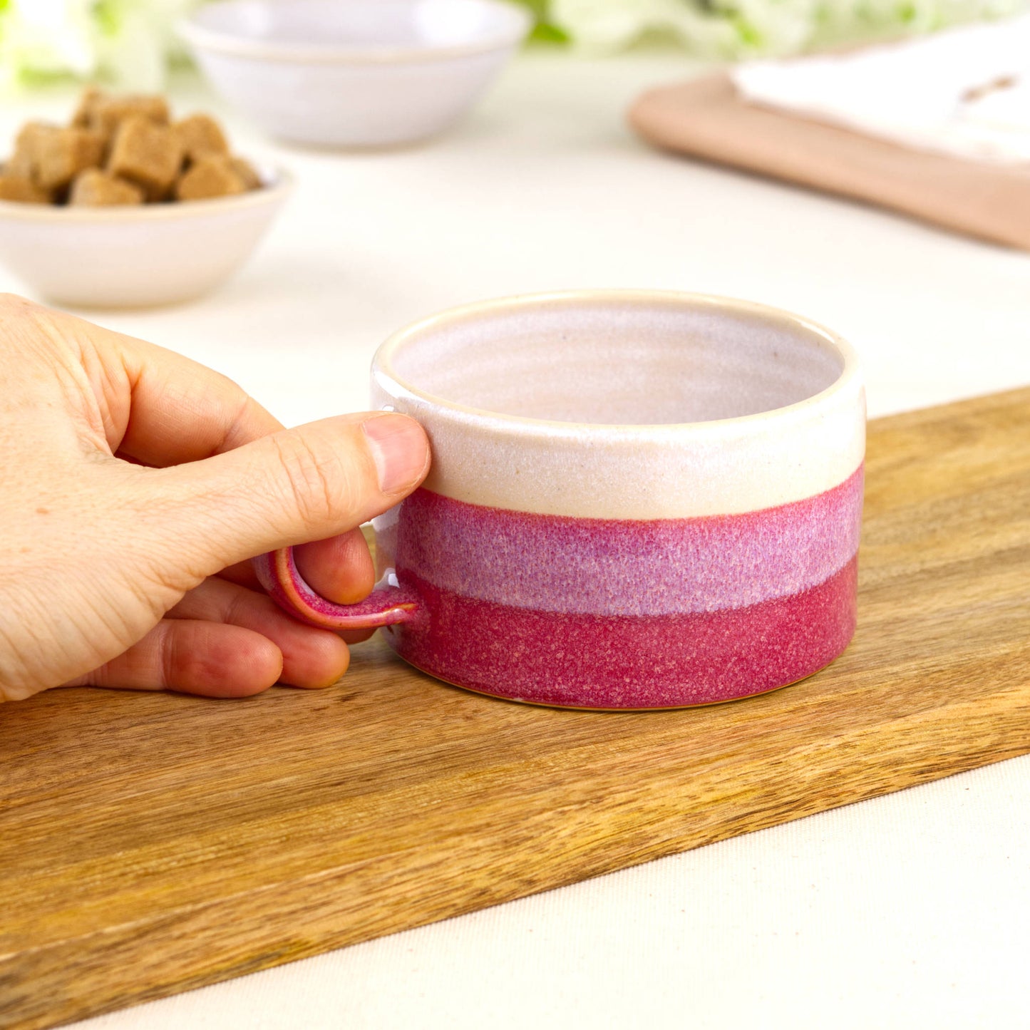 White and Crimson pottery coffee mug shown in hand, wheel-thrown café cup with smooth handle
