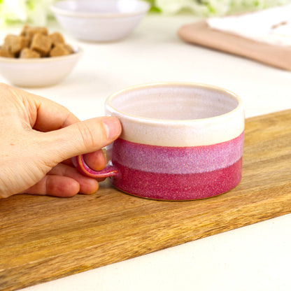 White and Crimson pottery coffee mug shown in hand, wheel-thrown café cup with smooth handle
