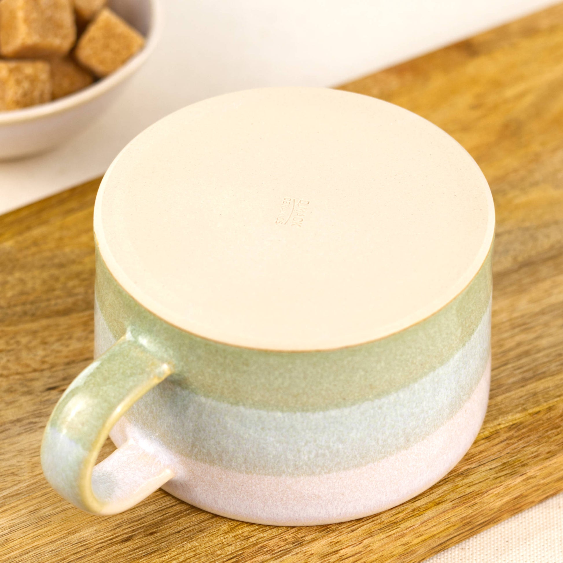 Underside of handmade stoneware cappuccino cup with smooth flat base and maker’s mark, small batch pottery mug