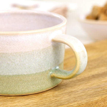 Close detail of white glaze blending into Pale Green on handcrafted cappuccino cup, glossy speckled artisan studio pottery finish
