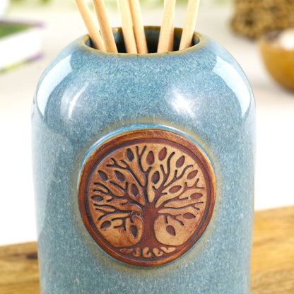 Close up of coastal blue fragrance diffuser with woodland tree of life badge and glossy speckled glaze