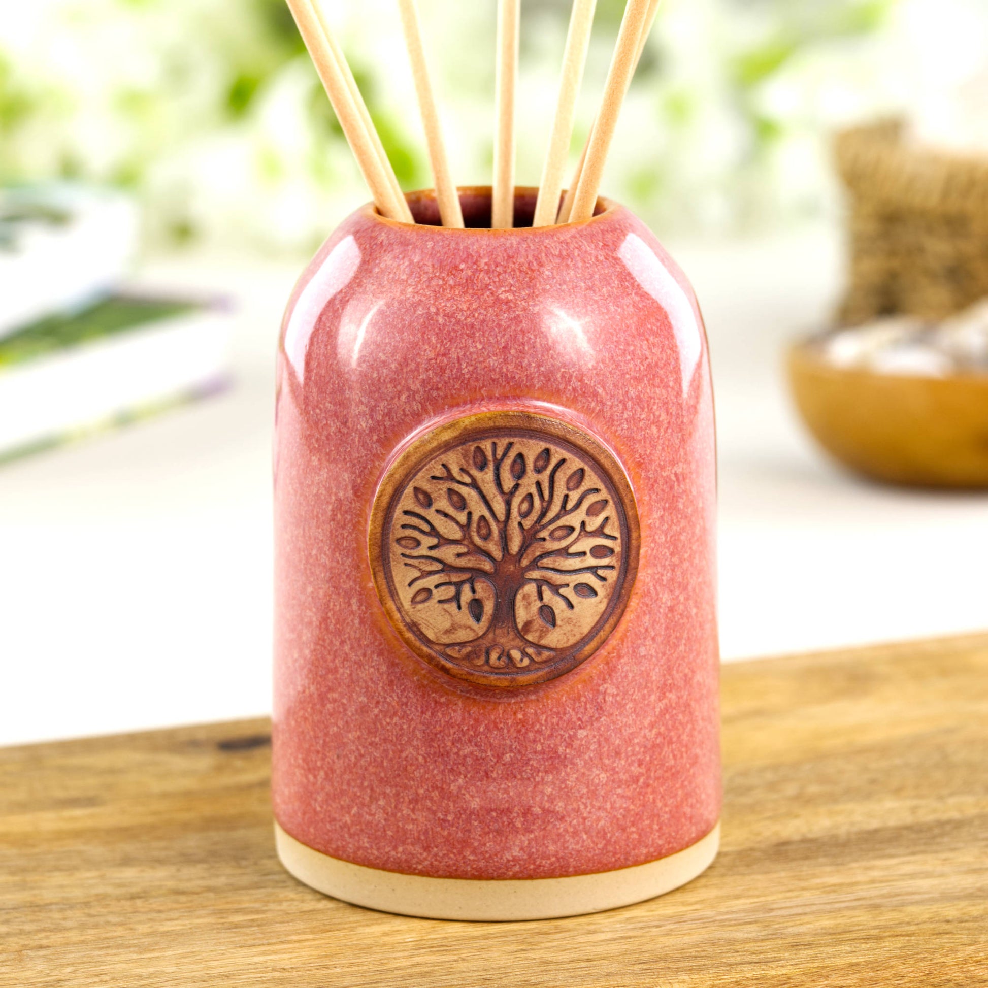 Coral ceramic reed diffuser with woodland tree emblem for shelf styling or cheerful bedside decor