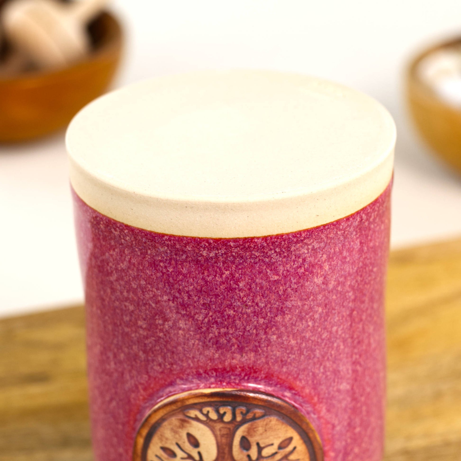 Base of handmade crimson ceramic diffuser vessel with smooth unglazed stoneware foot and maker stamp