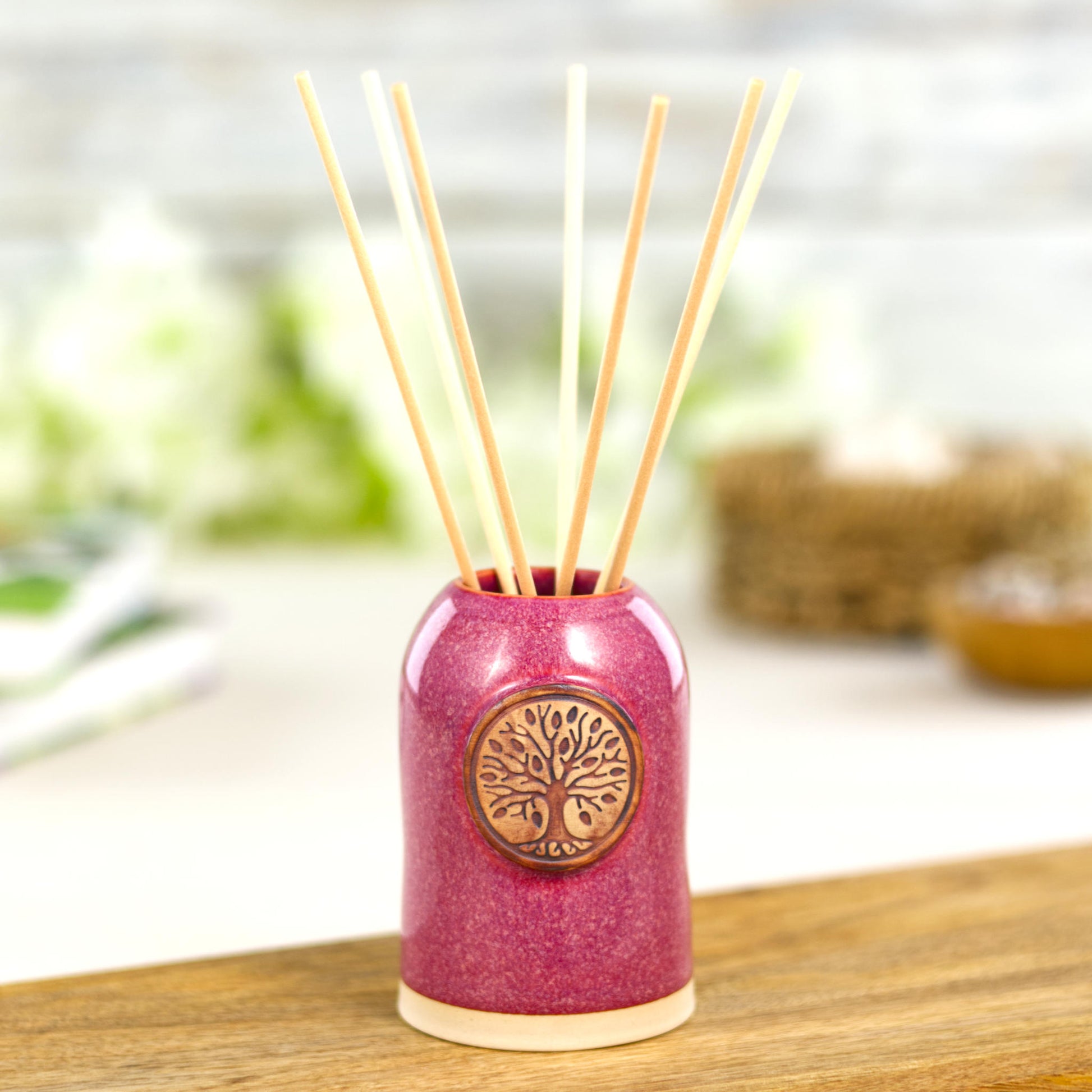 Handmade crimson reed diffuser with natural reeds for warm home fragrance and inviting bedroom decor