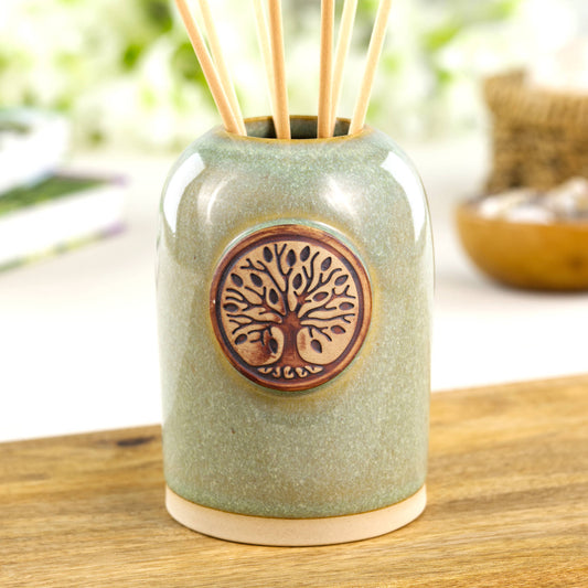Pale green ceramic reed diffuser with woodland tree emblem for shelf decor or bedside styling