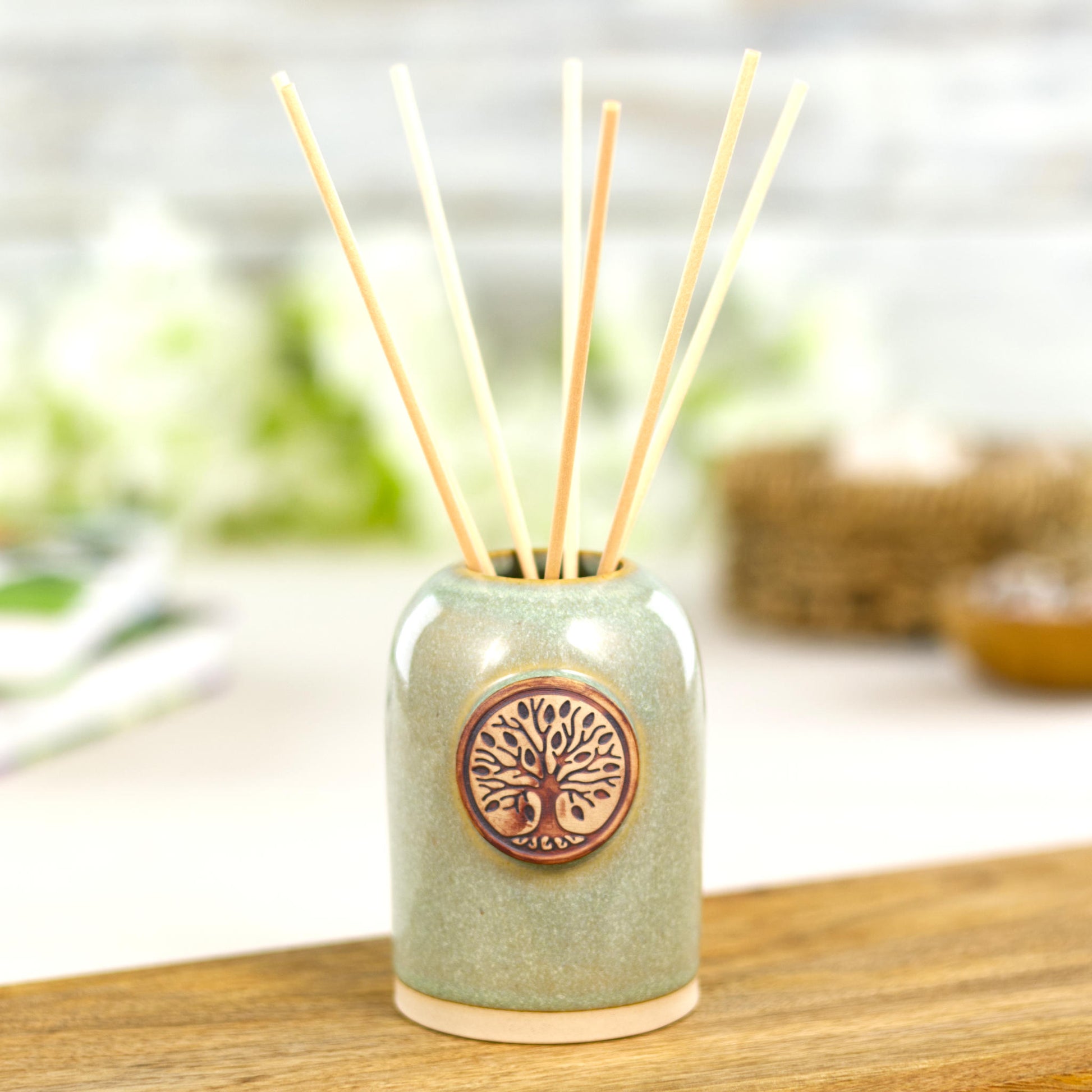 Handmade pale green reed diffuser with natural reeds for spa style bathroom decor.
