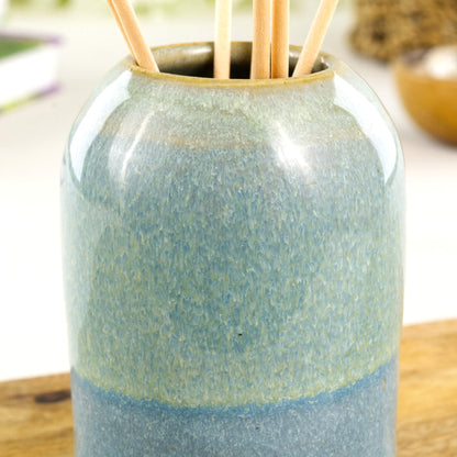 Wheel-thrown stoneware reed diffuser in Coastal Blue and Pale Green with glossy speckled glaze, layered colour bands and rounded neck detail