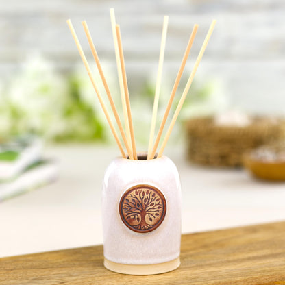 Handmade white ceramic reed diffuser with natural reeds for wabi-sabi interiors and peaceful bedroom decor.
