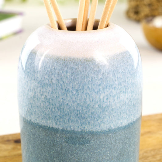 Close-up of layered flowing glazes on a Coastal Blue and White handmade ceramic reed diffuser vessel