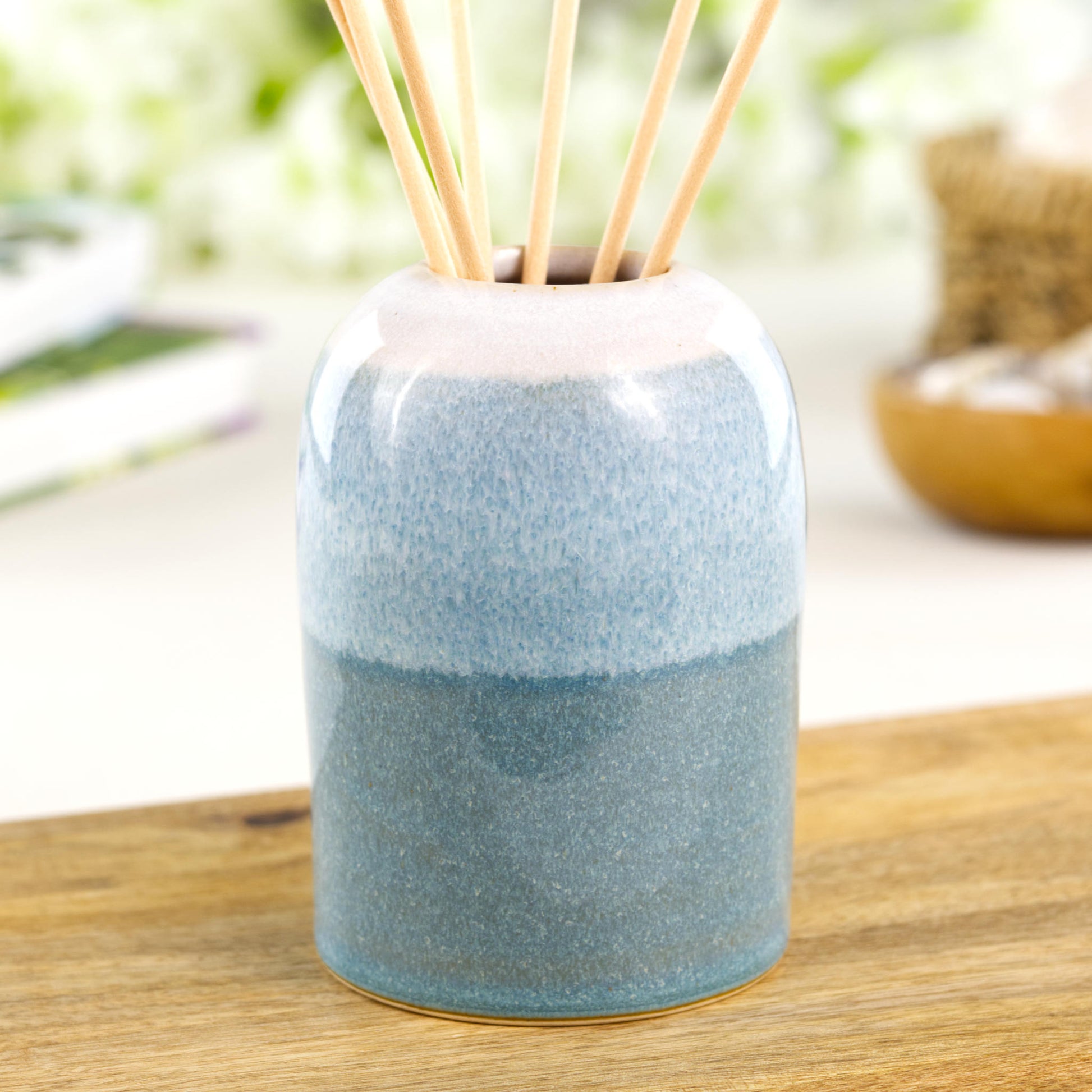 Minimalist Coastal Blue and White stoneware reed diffuser with layered glaze finish on wooden shelf