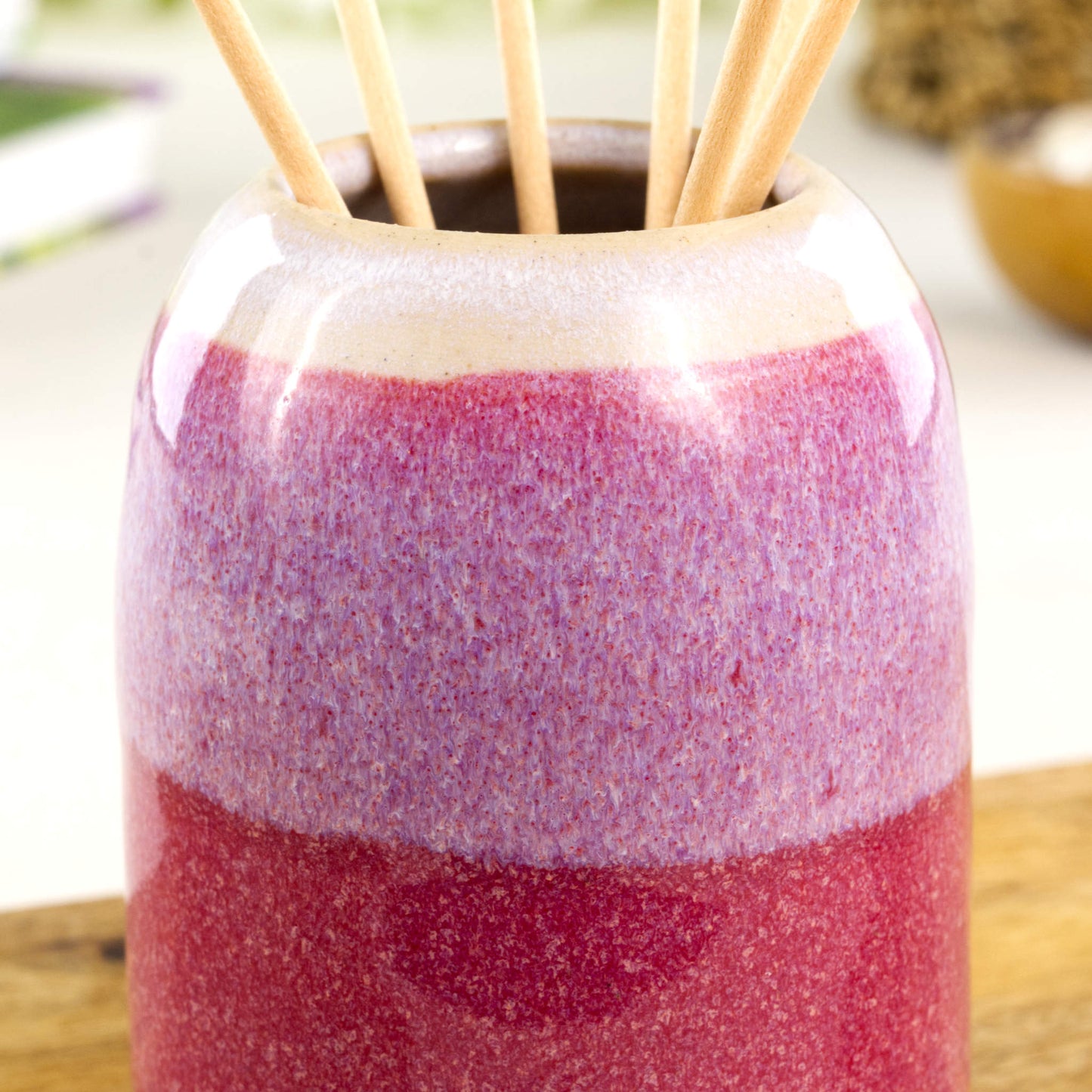 Wheel-thrown stoneware reed diffuser in crimson and white with glossy speckled glaze, layered colour band and rounded neck detail
