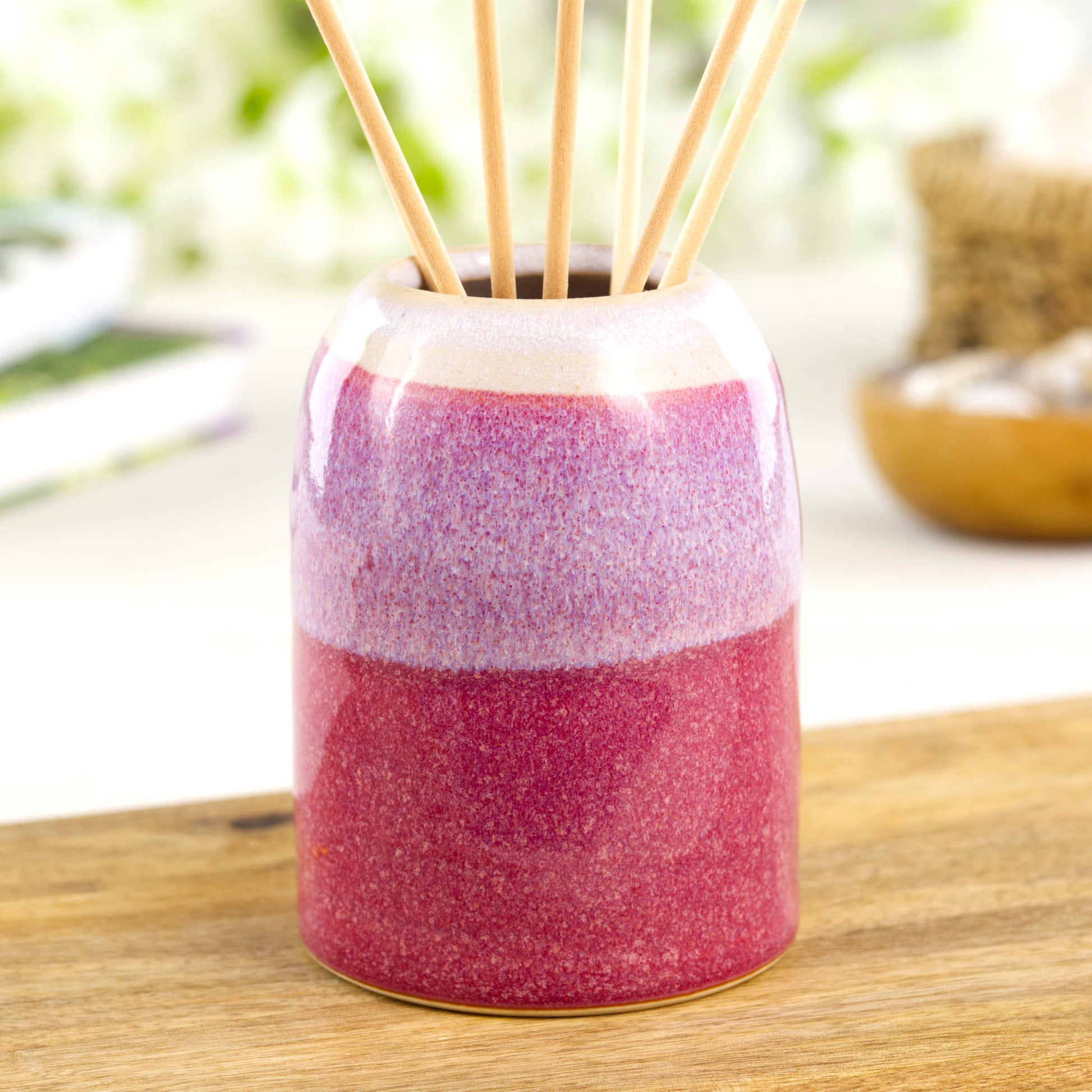 Crimson and white pottery reed diffuser with rounded modern form, artisan ceramic fragrance holder for bathroom or bedside table